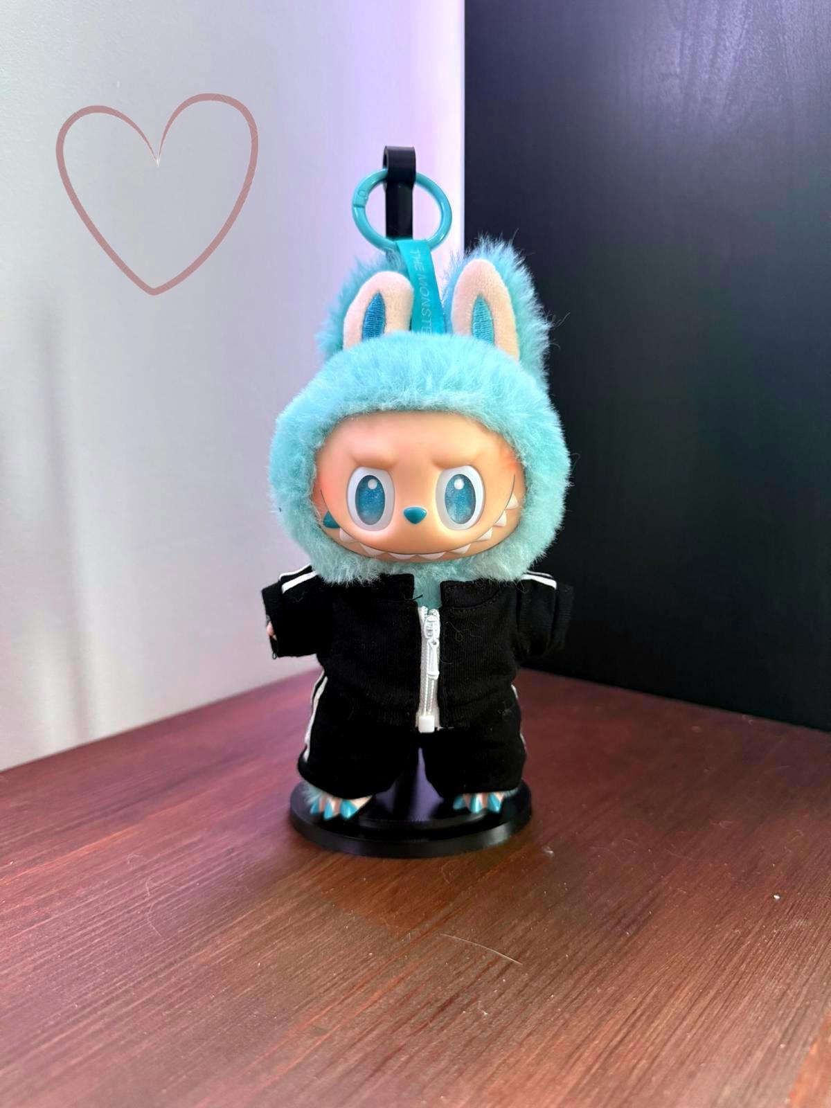 Toy figure with blue hood and black outfit on a wooden surface