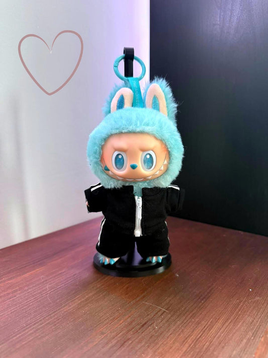 Toy figure with blue hood and black outfit on a wooden surface